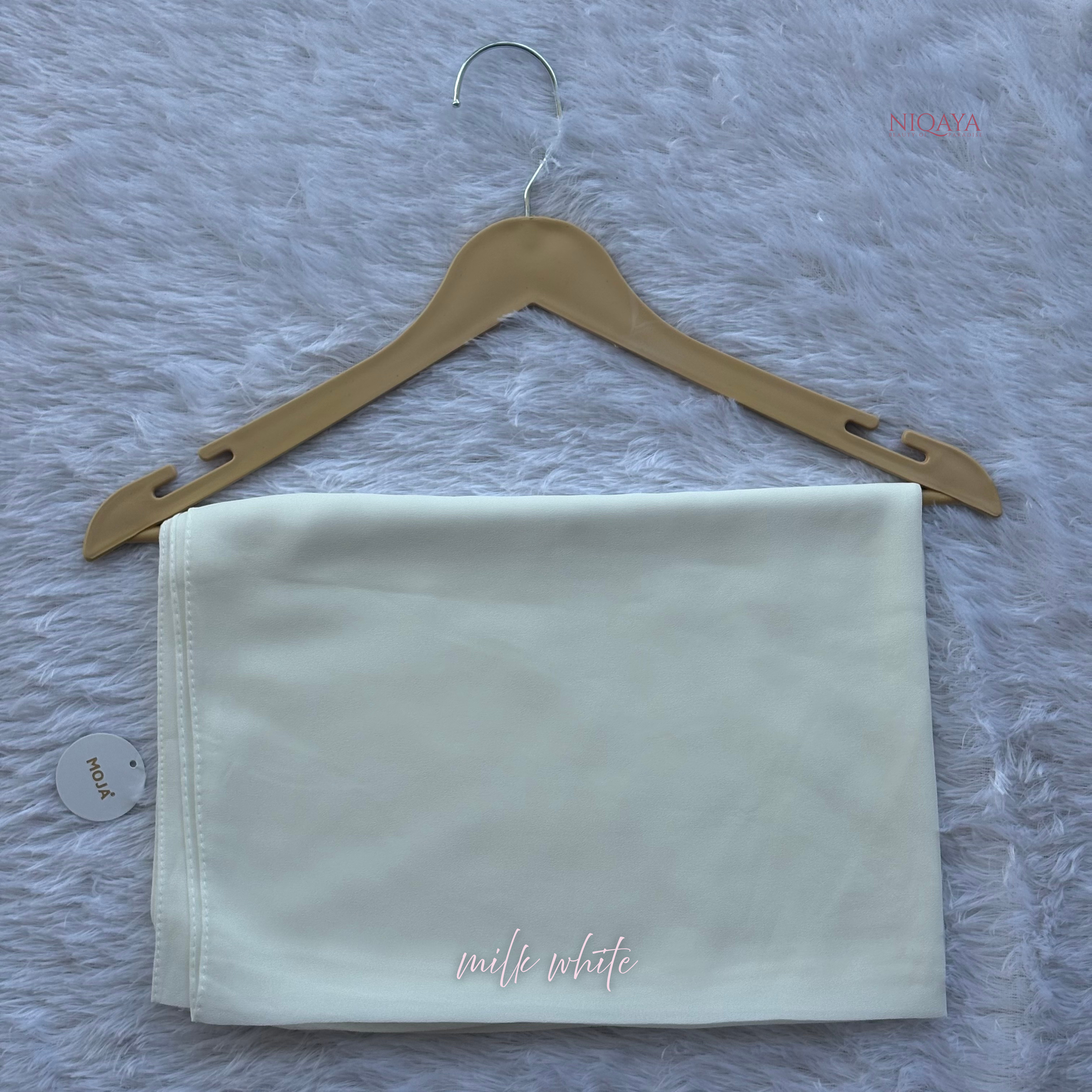 White fabric on a wooden hanger with 'milk white' text on a textured gray background