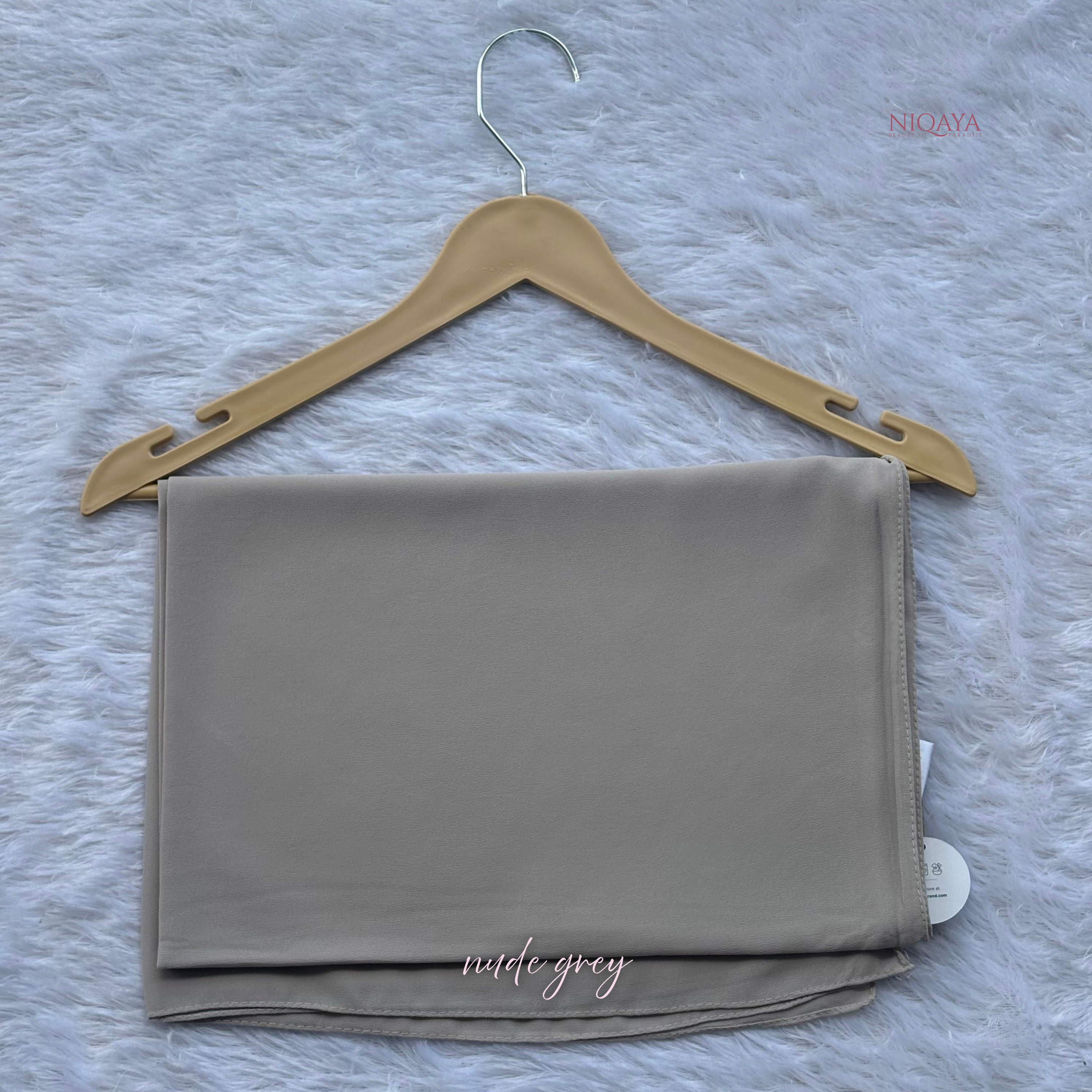 Folded gray fabric on a beige hanger against a textured gray background