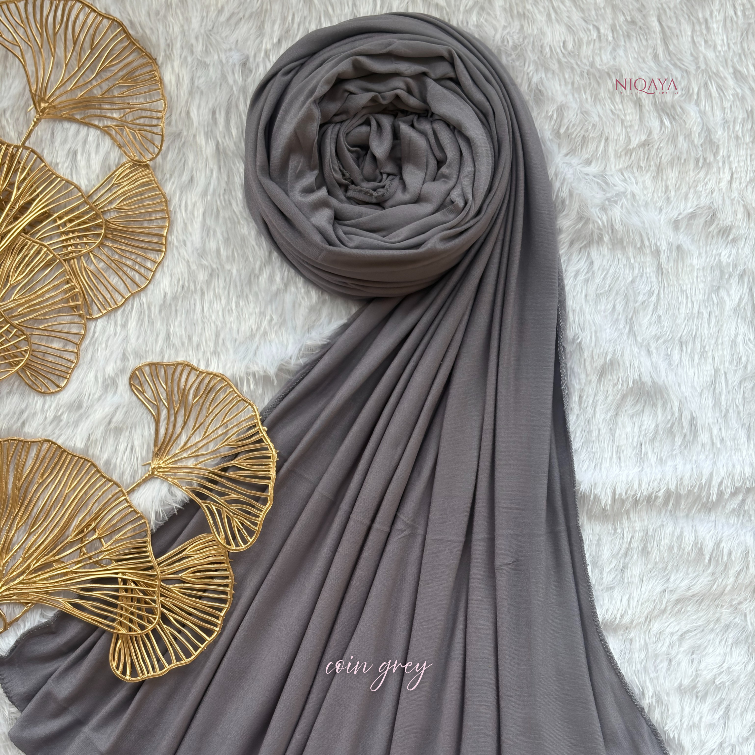 Gray hijab with gold leaf decorations on a textured surface