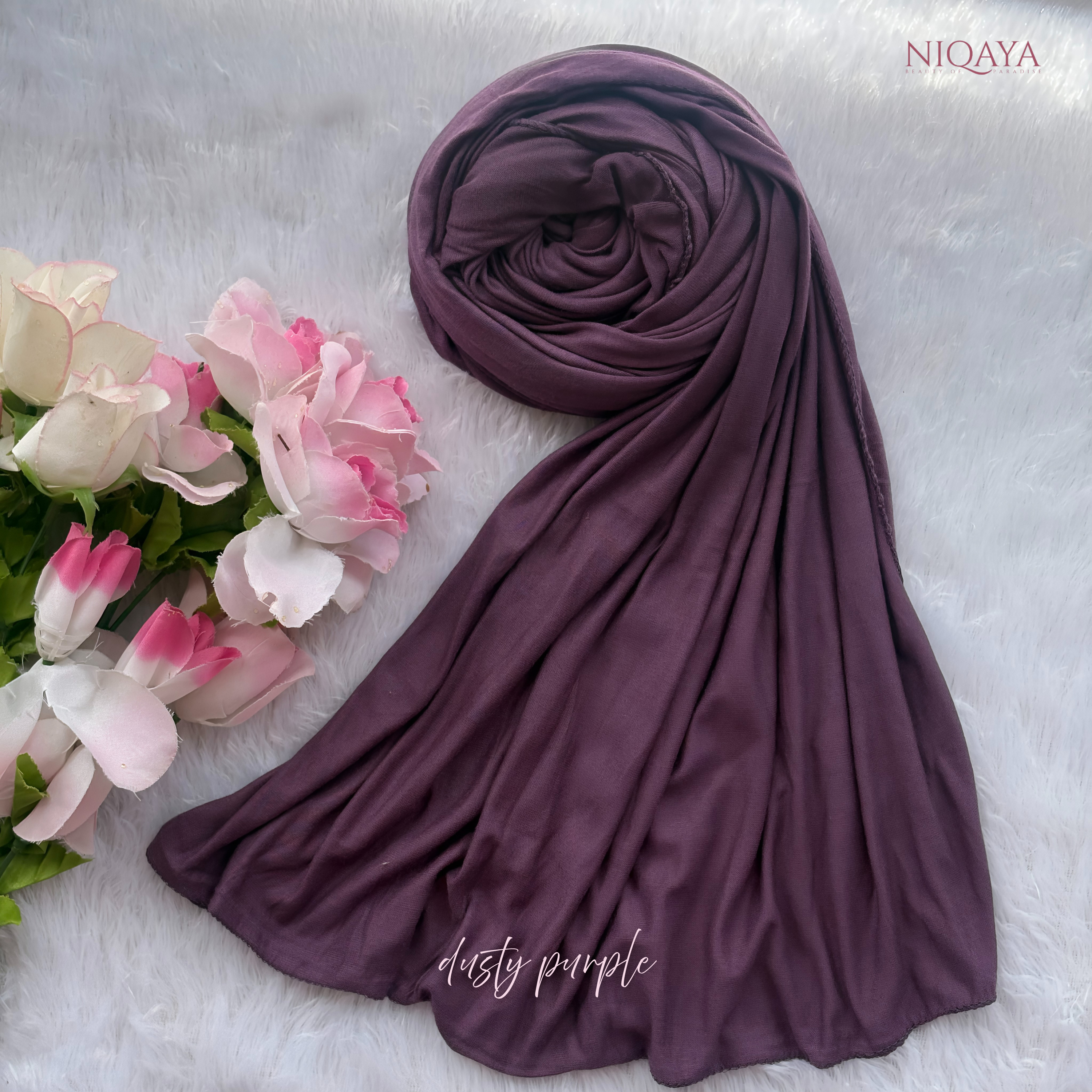 Purple hijab with flowers on a light gray background, featuring the brand 'NIQAYA'.