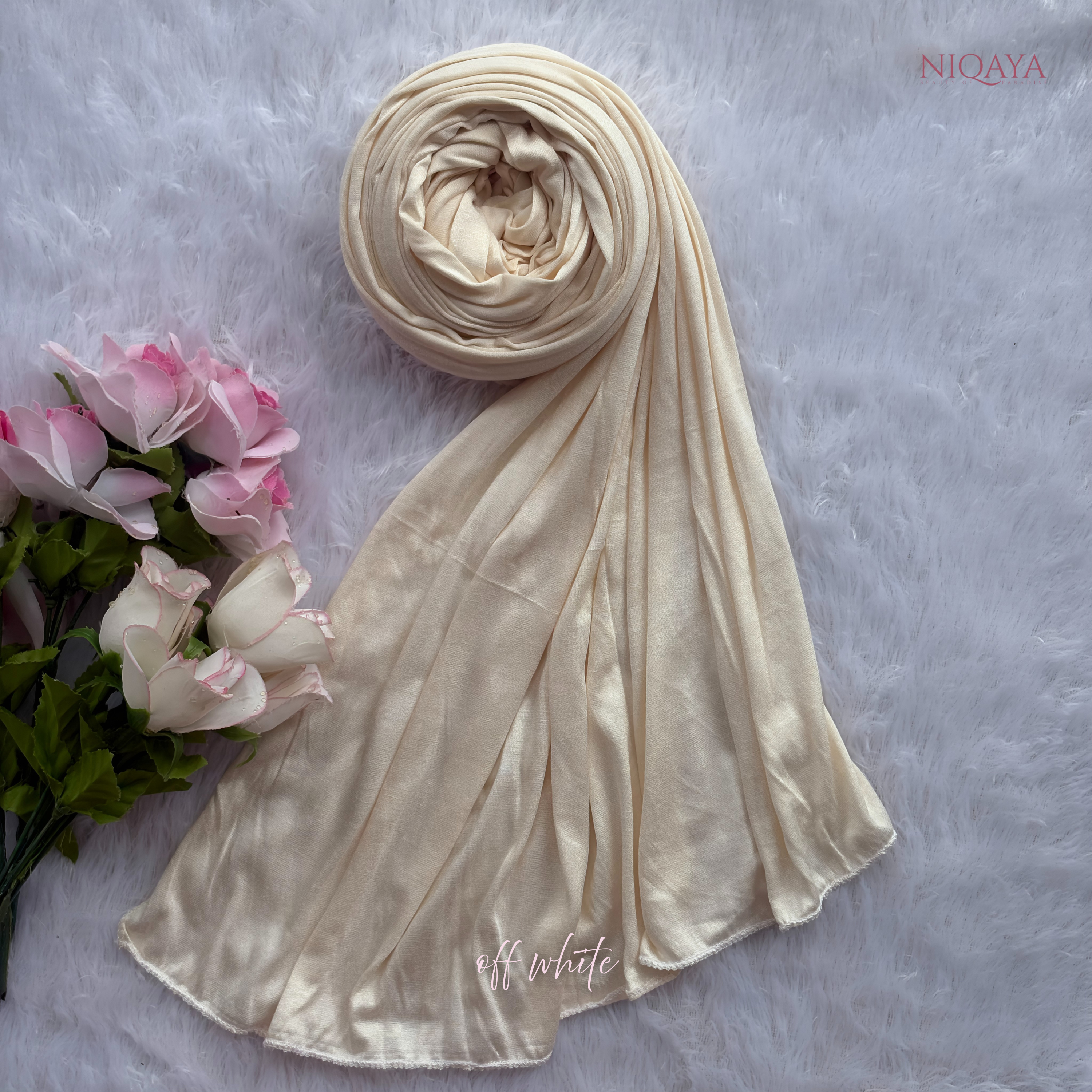 Beige hijab with pink flowers on a gray background, featuring the brand 'Niqaya'.