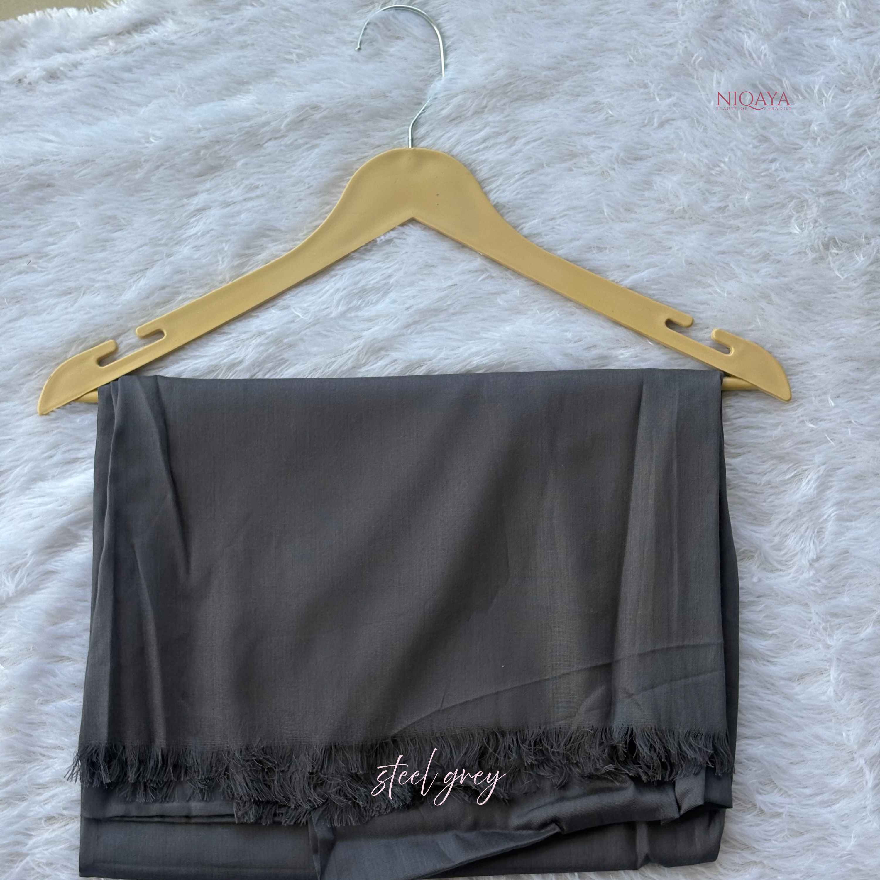 Steel grey scarf on a gold hanger with 'NIQAA' branding on a white textured background